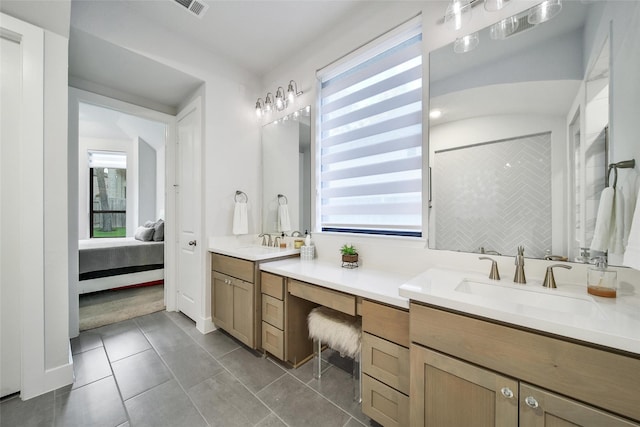 full bathroom with double vanity, a sink, and a healthy amount of sunlight