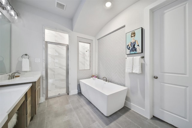 bathroom featuring visible vents, a freestanding bath, a stall shower, vanity, and tile patterned floors