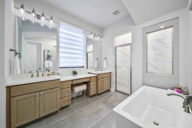 full bathroom with visible vents, a soaking tub, a shower stall, and vanity