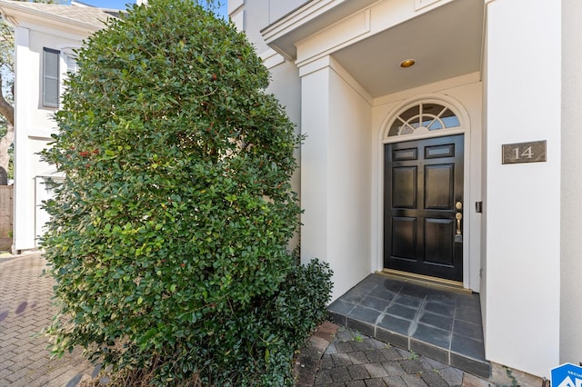 doorway to property featuring stucco siding