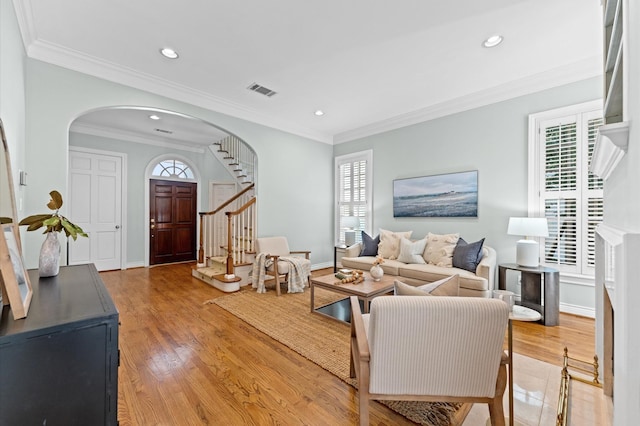 living area featuring light wood-type flooring, stairs, crown molding, and recessed lighting