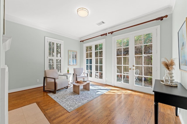 sitting room featuring ornamental molding, french doors, wood finished floors, and visible vents