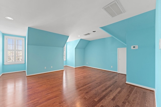 bonus room featuring lofted ceiling, baseboards, visible vents, and wood finished floors