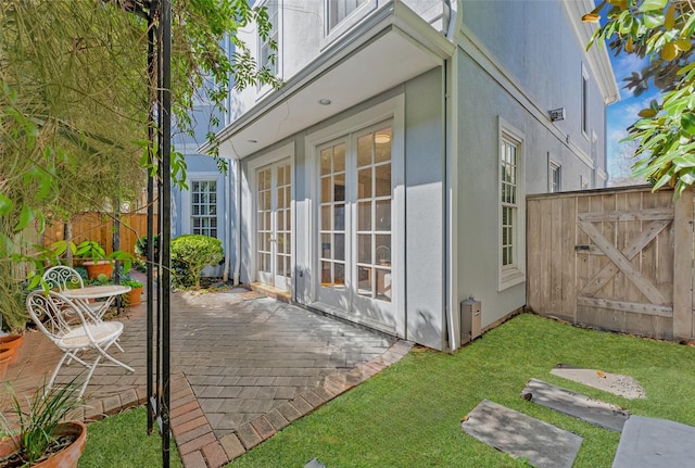 view of outdoor structure featuring french doors and fence