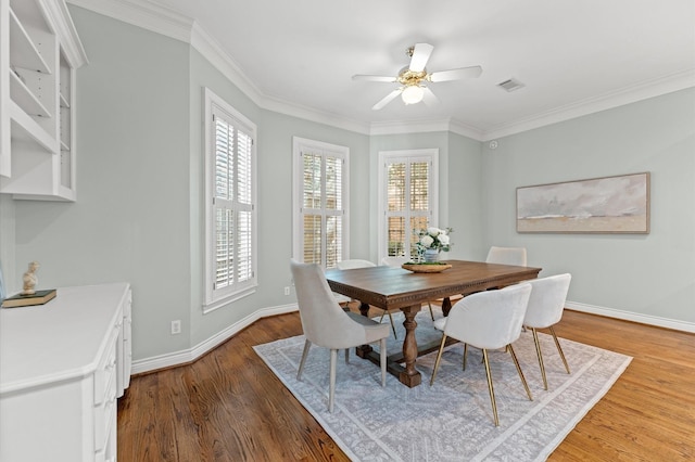 dining area featuring visible vents, baseboards, a ceiling fan, wood finished floors, and crown molding