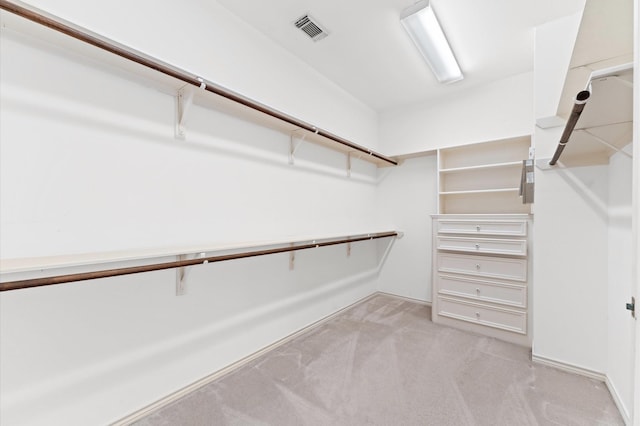 spacious closet with visible vents and light colored carpet