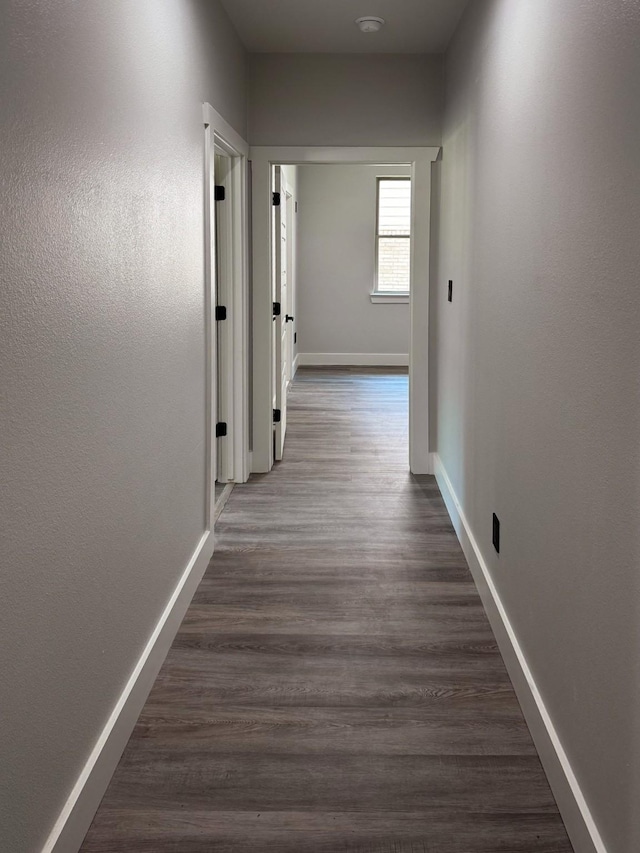 hall featuring dark wood finished floors and baseboards