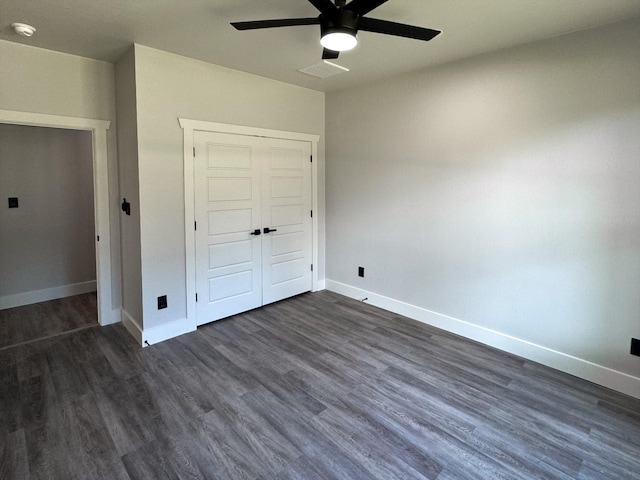 unfurnished bedroom with a closet, visible vents, dark wood-type flooring, a ceiling fan, and baseboards