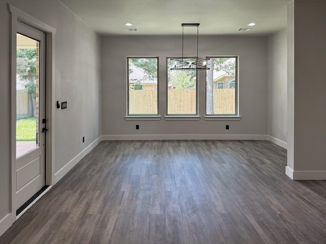 unfurnished dining area with dark wood-style flooring, visible vents, and baseboards