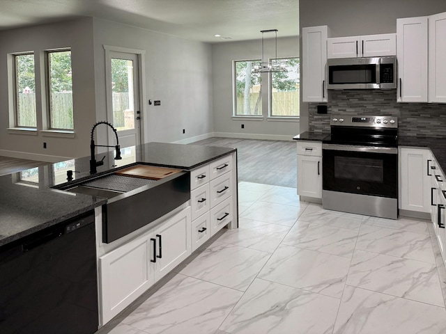 kitchen with white cabinets, appliances with stainless steel finishes, a sink, marble finish floor, and backsplash