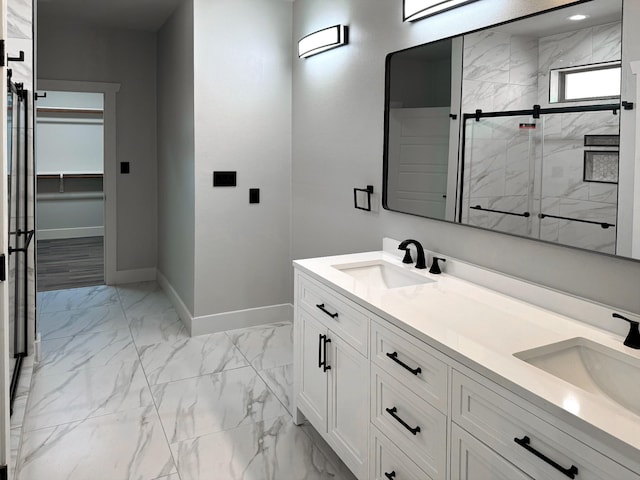 full bath with a stall shower, marble finish floor, a sink, and baseboards