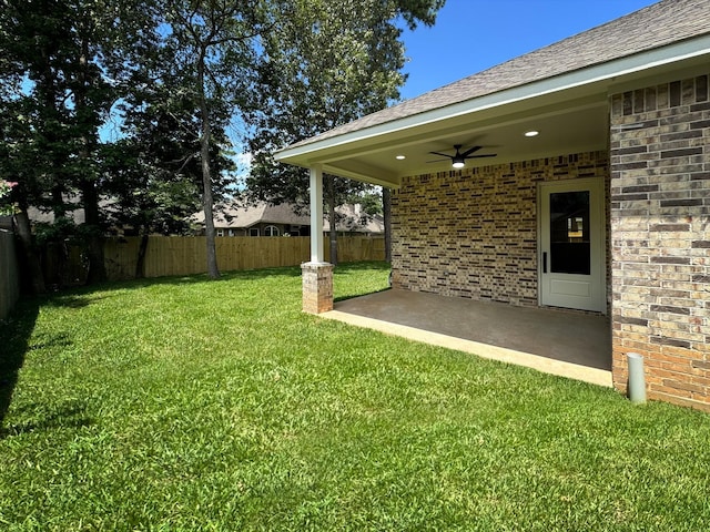 view of yard with fence private yard, a patio area, and a ceiling fan