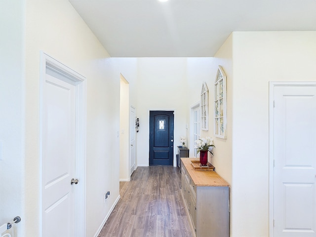 corridor featuring light wood-style flooring and baseboards