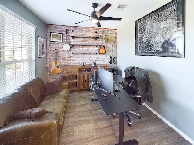 office space with a ceiling fan, baseboards, visible vents, and wood finished floors