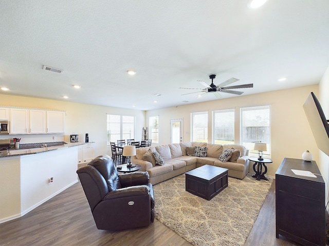 living room featuring dark wood-type flooring, visible vents, and recessed lighting