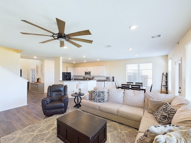 living room featuring a ceiling fan, recessed lighting, visible vents, and wood finished floors