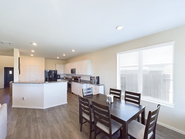 dining space with dark wood-style floors, recessed lighting, a healthy amount of sunlight, and visible vents