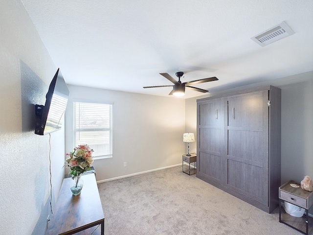 bedroom with baseboards, visible vents, a ceiling fan, and light colored carpet