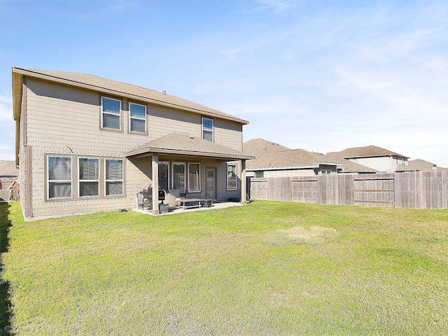 rear view of property with a lawn, a patio area, and a fenced backyard