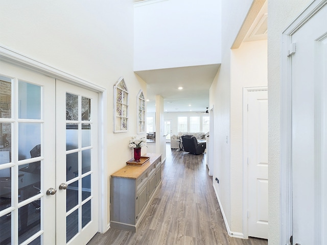 hallway featuring french doors, wood finished floors, and recessed lighting