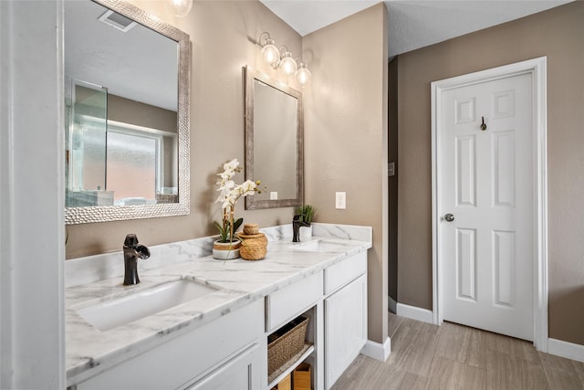 bathroom with visible vents, vanity, and baseboards