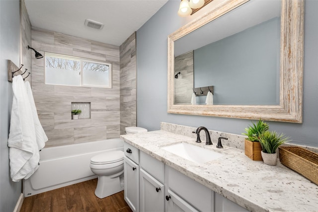 bathroom with shower / tub combination, toilet, wood finished floors, visible vents, and vanity