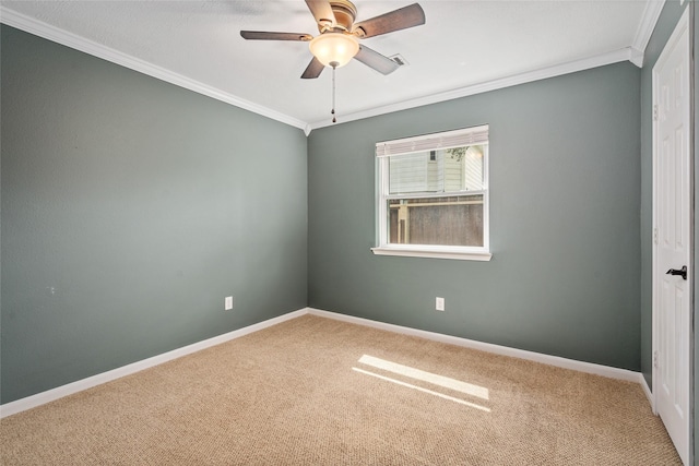 spare room with ornamental molding, carpet, a ceiling fan, and baseboards