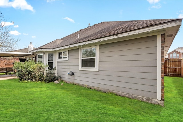 back of house with a patio area, fence, a lawn, and roof with shingles