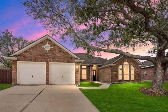 view of front facade featuring a garage, a front yard, brick siding, and driveway