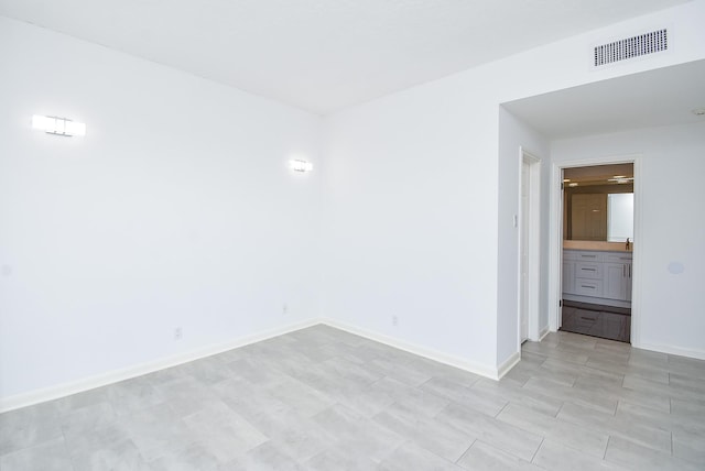 unfurnished room featuring light wood finished floors, baseboards, and visible vents