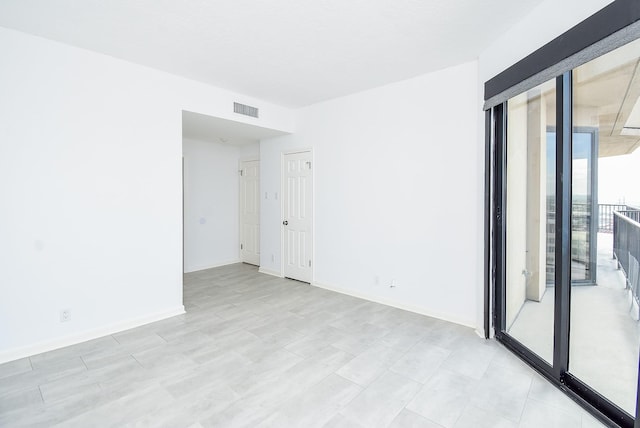 spare room featuring baseboards and visible vents