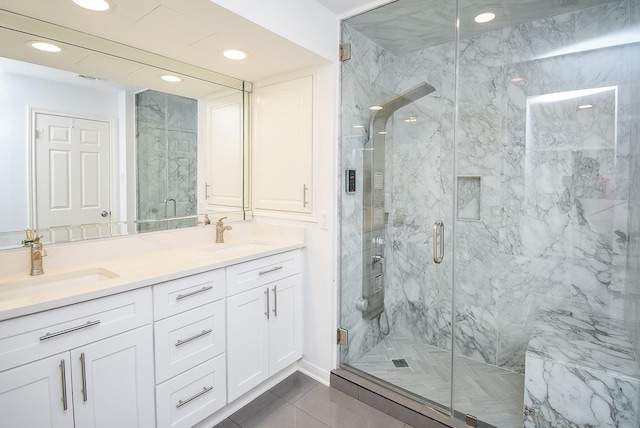 bathroom with a sink, a marble finish shower, and double vanity