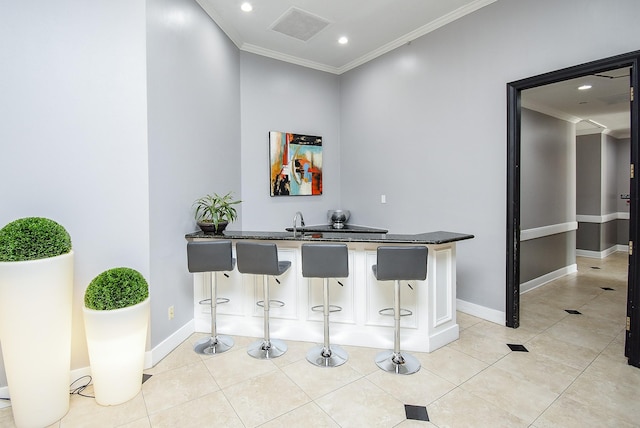 bar with light tile patterned floors, visible vents, baseboards, crown molding, and recessed lighting