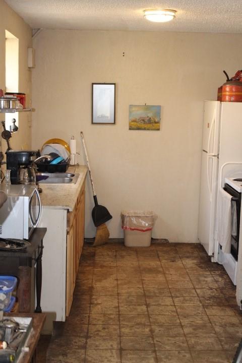 kitchen featuring light countertops, a sink, and a textured ceiling