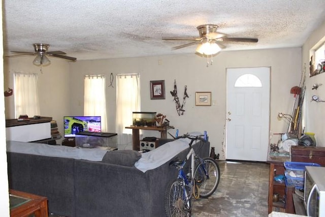 living room featuring a textured ceiling, concrete floors, and a ceiling fan