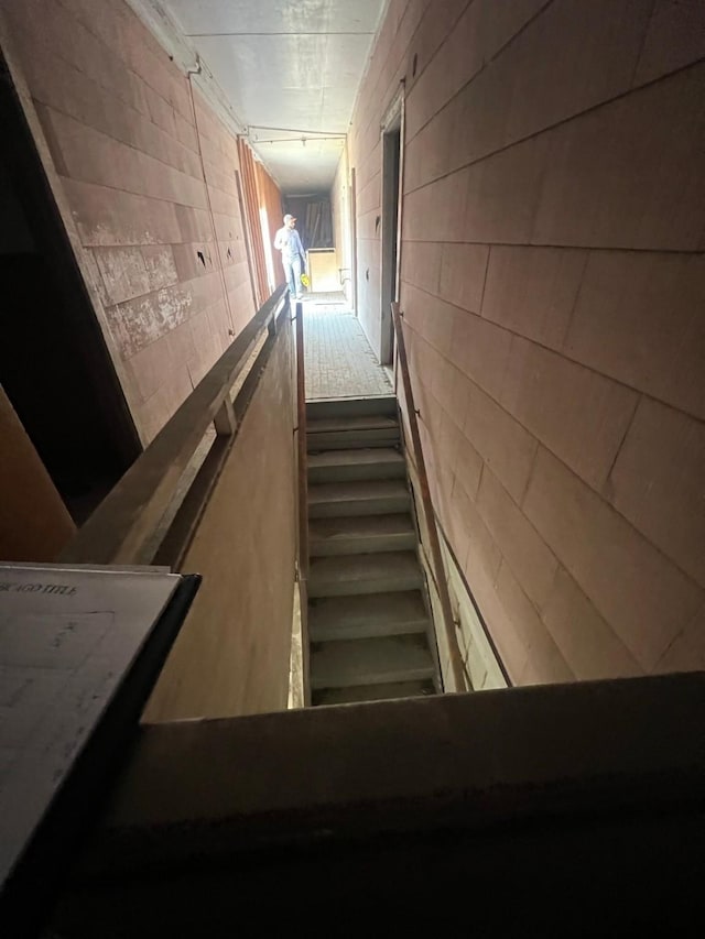 staircase featuring concrete block wall