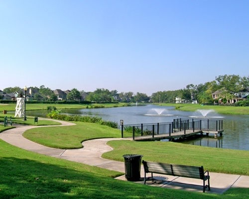 view of property's community with a water view and a lawn