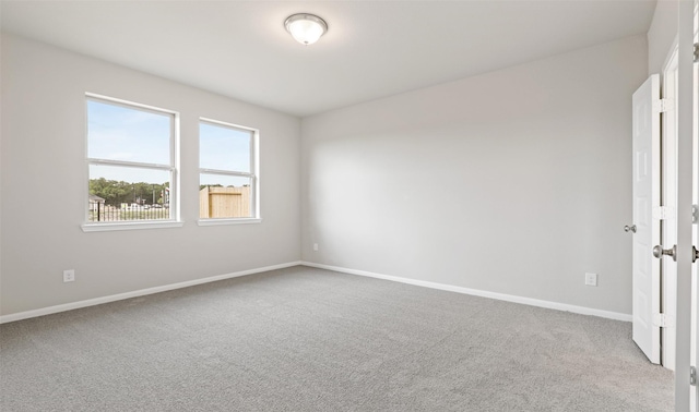 empty room featuring carpet flooring and baseboards