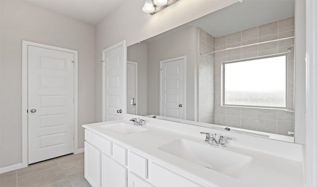 bathroom featuring a sink, tile patterned floors, double vanity, and baseboards
