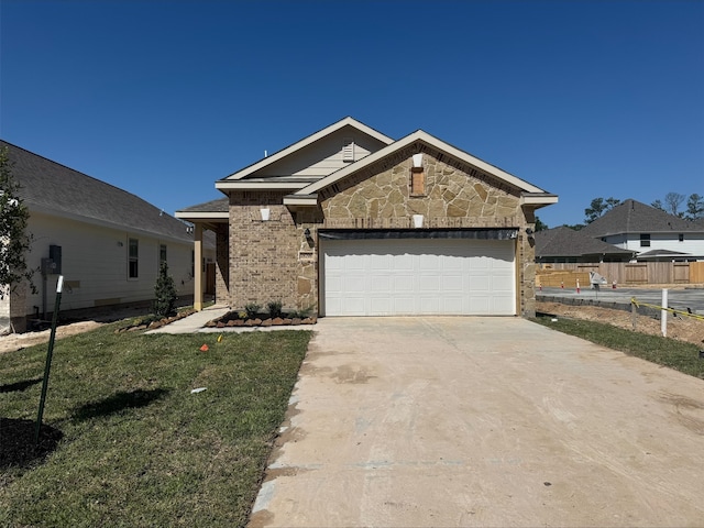 view of front of home featuring driveway, stone siding, a front yard, brick siding, and a garage