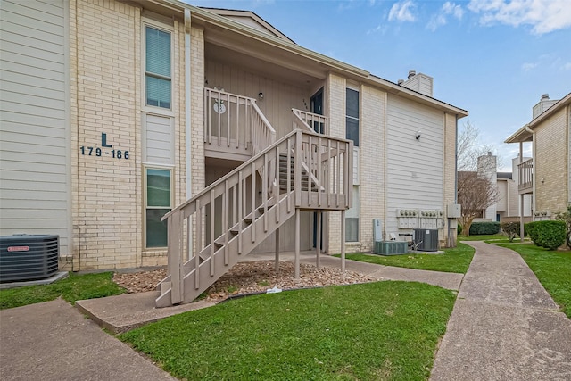 view of property with stairs and central AC unit