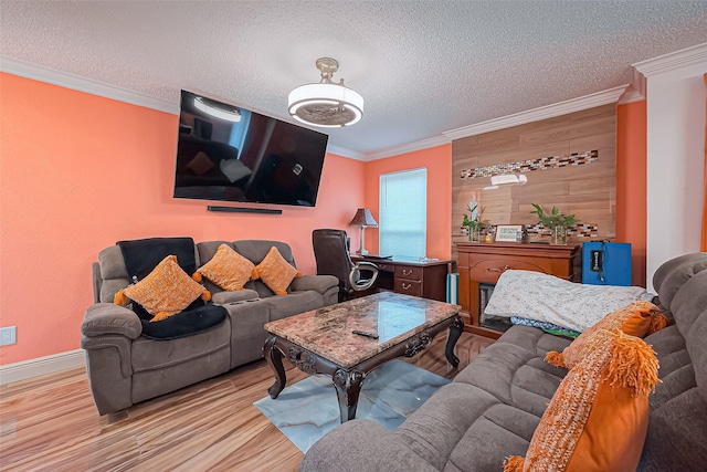 living room featuring a textured ceiling, baseboards, crown molding, and wood finished floors