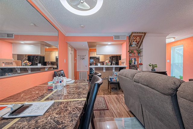 dining space featuring ornamental molding, wood finished floors, and visible vents