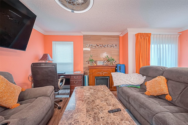 living area with crown molding, a textured ceiling, and wood finished floors