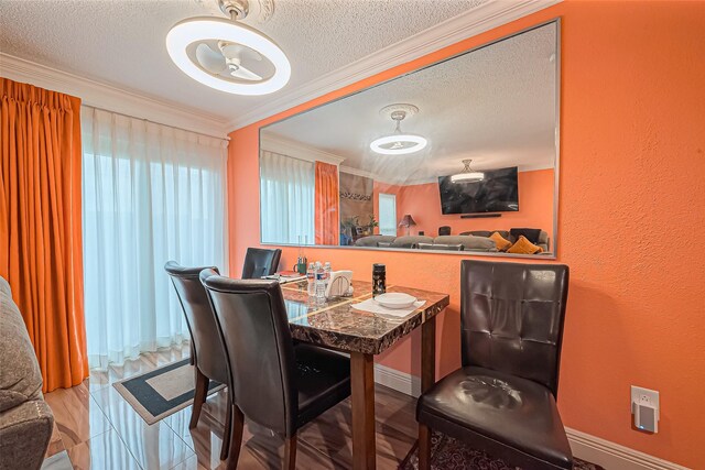 dining area with ornamental molding, a textured wall, a textured ceiling, and baseboards