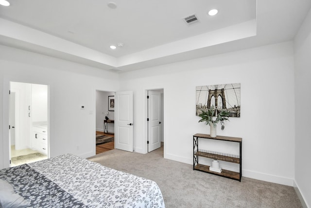 bedroom with baseboards, visible vents, a tray ceiling, and carpet flooring