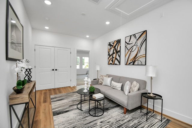 living room featuring attic access, baseboards, wood finished floors, and recessed lighting