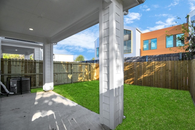 view of yard featuring a patio area, a fenced backyard, and central air condition unit