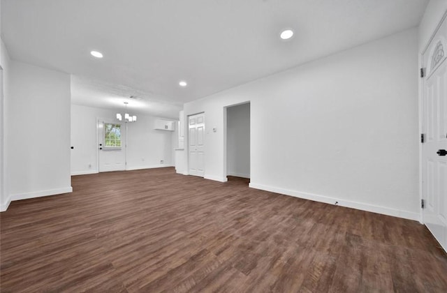 interior space featuring dark wood-type flooring, recessed lighting, baseboards, and an inviting chandelier