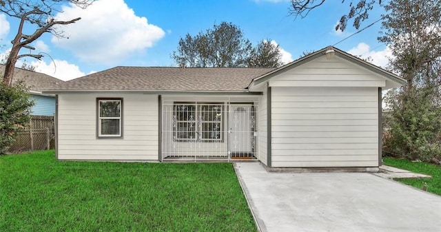 ranch-style home featuring roof with shingles, fence, a patio, and a front yard